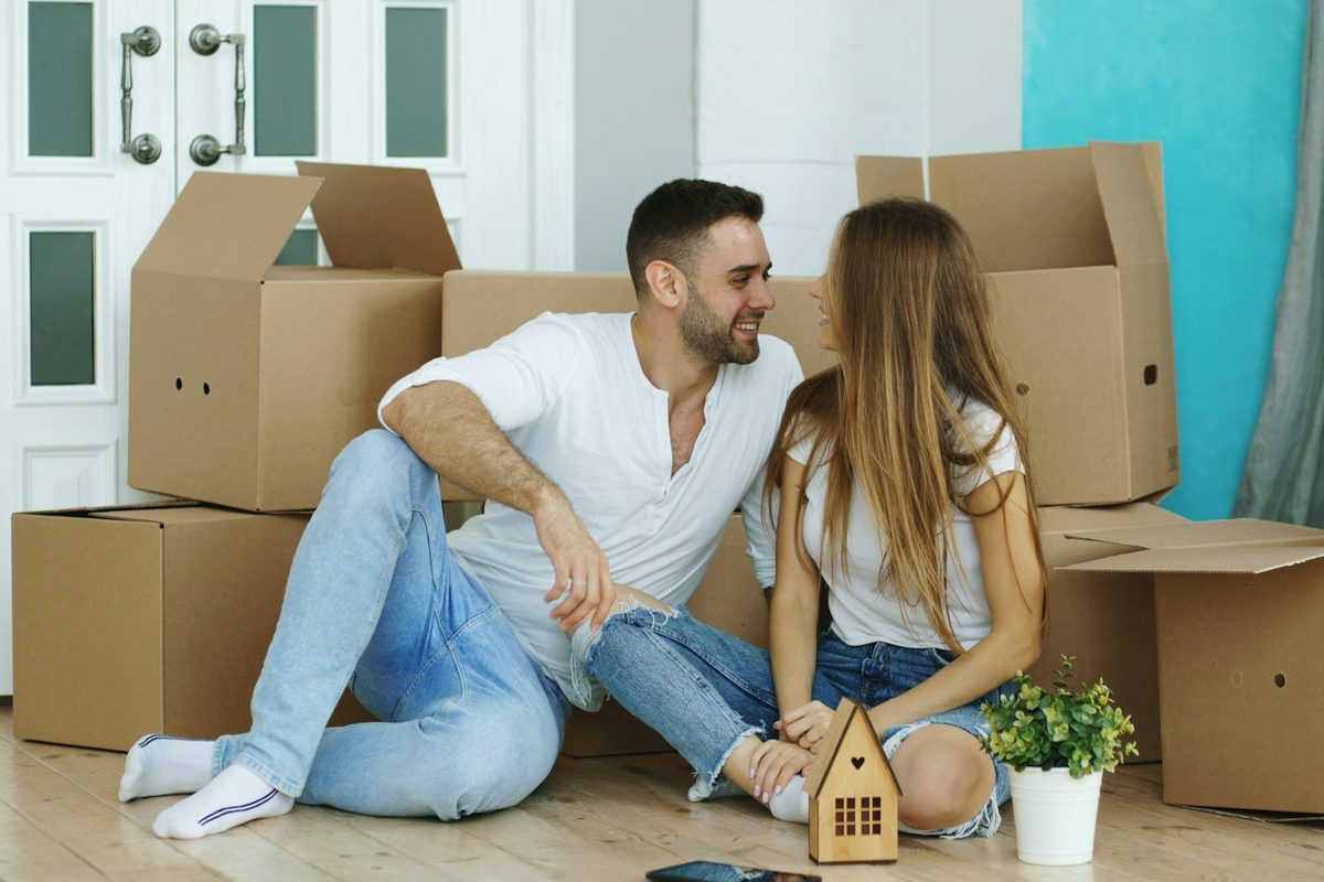 Stel tussen verhuisdozen in hun nieuwe huis